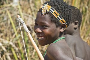 A photo of a smiling young Hadza hunter girl.