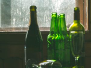 empty liquor bottles near a dirty window